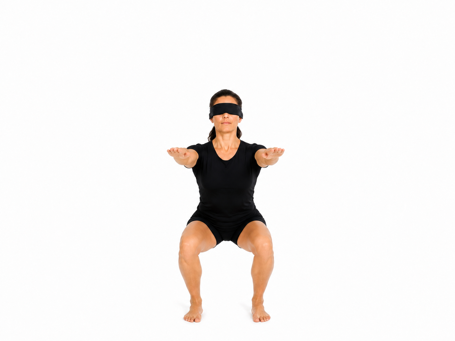 A blindfolded practitioner holding a deep squat with arms extended forward